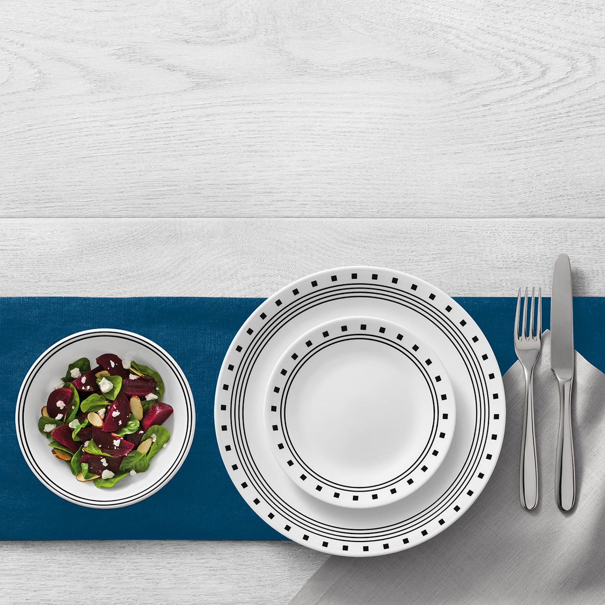 White CORELLE City Block dinnerware set with plates and bowls arranged on a table, showcasing durable ceramic design.