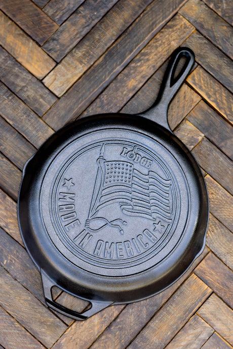 Lodge classic cast iron skillet with US flag design, 25.4 cm diameter, outdoor cooking pan with sturdy handle.